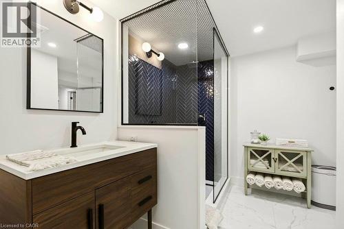 Modern vanity with white countertop, sleek black faucet, and framed mirror - 9 Midway Street, Hamilton, ON 