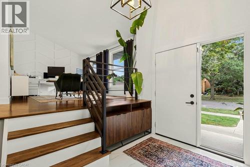 Vaulted ceilings, wood-finish flooring, white walls, black metal staircase railing, and a wood-finish console cabinet - 9 Midway Street, Hamilton, ON 