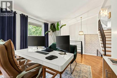 Hardwood flooring, vaulted ceiling, contemporary pendant lighting, metal stair railing, and a window with exterior views - 9 Midway Street, Hamilton, ON 