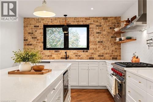 Brick accent wall with a black framed window - 9 Midway Street, Hamilton, ON 