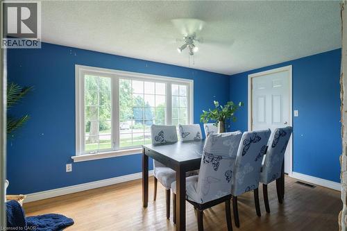 Expansive window with white trim, wood-finish flooring, and white paneled door - 78 Oak Street, Simcoe, ON 