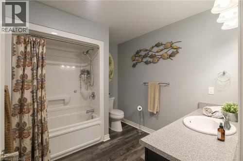 Tub/shower combination with a single-handle faucet, vanity with an integrated sink, and wood-finish flooring - 78 Oak Street, Simcoe, ON 