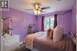Recessed window with white trim, ceiling fan with light fixture, wood-finish flooring - 
