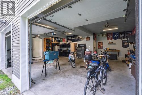 Concrete flooring garage with an overhead door, recessed lighting, ceiling fan, and built-in shelving - 78 Oak Street, Simcoe, ON 