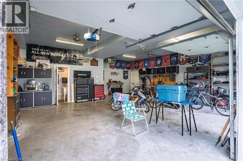 Attached garage with a concrete floor, built-in storage cabinetry, overhead lighting, and an overhead garage door - 78 Oak Street, Simcoe, ON 