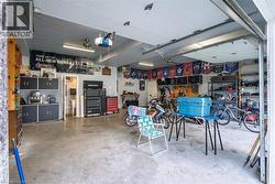 Attached garage with a concrete floor, built-in storage cabinetry, overhead lighting, and an overhead garage door - 