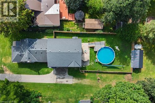 Expansive backyard with a fenced perimeter, manicured lawn, and an above-ground swimming pool - 78 Oak Street, Simcoe, ON 
