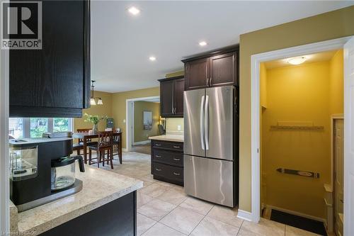 Tile flooring, dark wood-finish cabinetry, stainless steel refrigerator, recessed lighting, and a well-lit entryway - 78 Oak Street, Simcoe, ON 