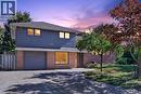 Brick and siding exterior with an attached garage, paved driveway, and mature landscaping - 3028 Eva Drive, Burlington, ON 