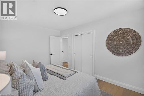 Light wood-finish flooring, white walls, and a contemporary flush-mount ceiling light - 3028 Eva Drive, Burlington, ON 