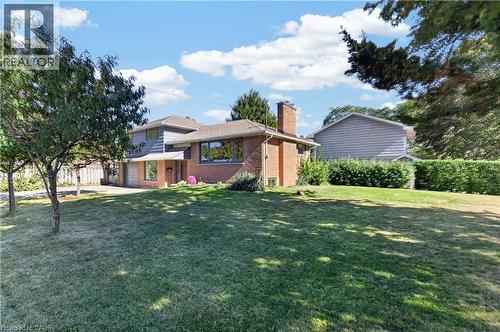 Brick and siding exterior with multiple windows, an attached chimney, and a front entry - 3028 Eva Drive, Burlington, ON 
