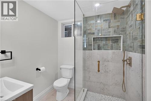 Glass-enclosed shower with a rainfall showerhead, mosaic tile surround, and built-in niche - 3028 Eva Drive, Burlington, ON 