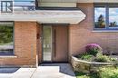 Brick exterior with an integrated planter box and a wood-finish entry door with a sidelight - 3028 Eva Drive, Burlington, ON 