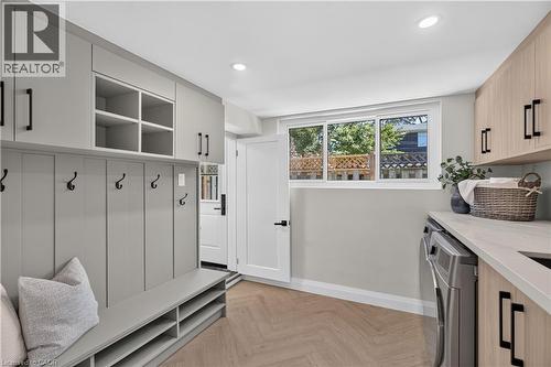 Built-in cabinetry with open shelving, herringbone wood-finish flooring, and a large window - 3028 Eva Drive, Burlington, ON 