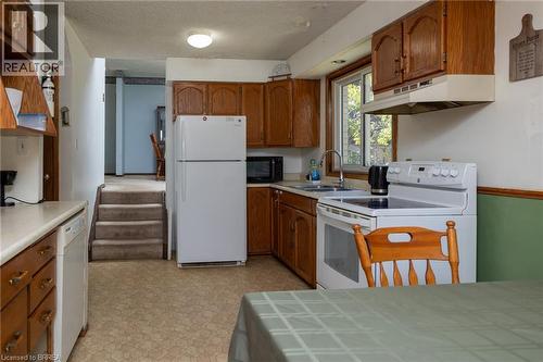 Kitchen featuring wood cabinetry and an electric range with an overhead hood - 52 Brier Park Road, Brantford, ON 
