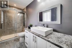 Glass-enclosed shower with full-height stone-look tile surround - 
