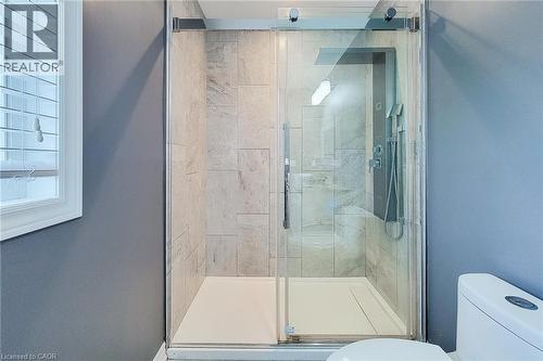 Glass-enclosed shower with a multi-function shower panel and light-toned tile surround - 4274 Sixth Avenue, Niagara Falls, ON 