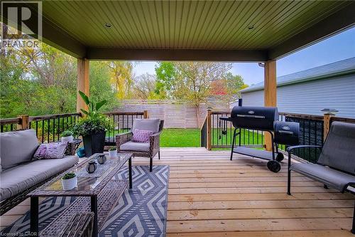 Covered wood deck with slatted ceiling, wood pillars, and black metal railings - 4274 Sixth Avenue, Niagara Falls, ON 