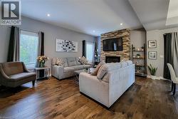 Wood-finish flooring throughout, recessed lighting, and a stone-clad fireplace - 
