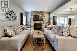Wood-finish flooring, stone-clad fireplace, recessed lighting, and sliding glass door - 
