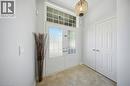 White double-entry doors with frosted glass panels, transom window, recessed lighting, and a decorative light fixture - 3352 Hiscott Avenue, Burlington, ON 