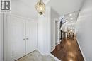 Recessed lighting, wood-finish flooring, staircase with dark wood railings, paneled bi-fold doors, and a decorative pendant light fixture - 3352 Hiscott Avenue, Burlington, ON 