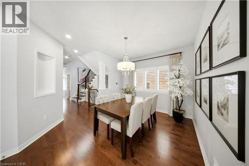 Wood-finish flooring, recessed lighting, built-in wall niche, multiple windows with plantation shutters, and a chandelier lighting fixture - 3352 Hiscott Avenue, Burlington, ON 
