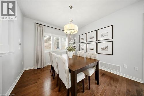 Hardwood-finish flooring, white plantation shutters, drum pendant light fixture, and crown molding - 3352 Hiscott Avenue, Burlington, ON 