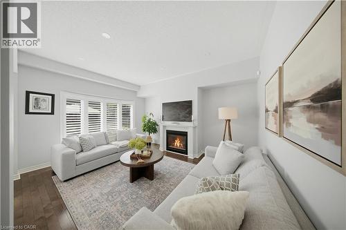 Wood-finish flooring, recessed lighting, fireplace with mantel, window with plantation shutters, light neutral wall color - 3352 Hiscott Avenue, Burlington, ON 