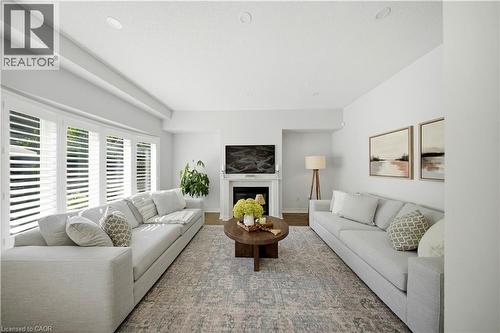 Recessed lighting, light-toned walls, wood-finish flooring, a white fireplace with a mantel, and plantation shutters - 3352 Hiscott Avenue, Burlington, ON 