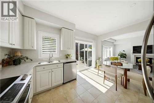 White shaker cabinetry, stainless steel appliances, tile flooring, glass sliding doors, and recessed lighting - 3352 Hiscott Avenue, Burlington, ON 