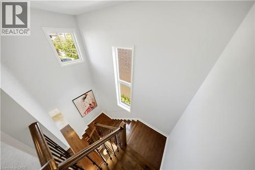 Hardwood staircase featuring dark wood newel posts and metal balusters - 3352 Hiscott Avenue, Burlington, ON 