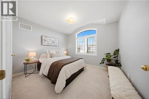 Arched window with plantation shutters, light-colored carpeting, and light gray wall paint - 3352 Hiscott Avenue, Burlington, ON 