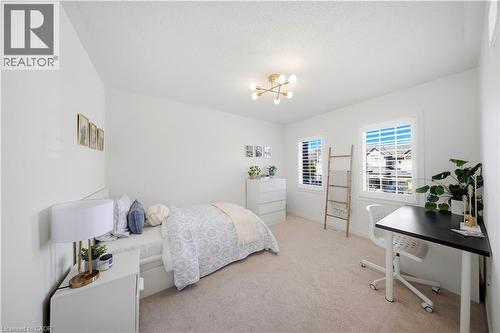 Recessed windows with plantation shutters, light-toned carpet flooring, and a modern ceiling light fixture - 3352 Hiscott Avenue, Burlington, ON 
