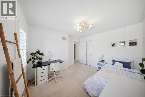 Neutral wall finishes, recessed window with white plantation shutters, soft carpet flooring, and a modern ceiling light fixture - 3352 Hiscott Avenue, Burlington, ON 