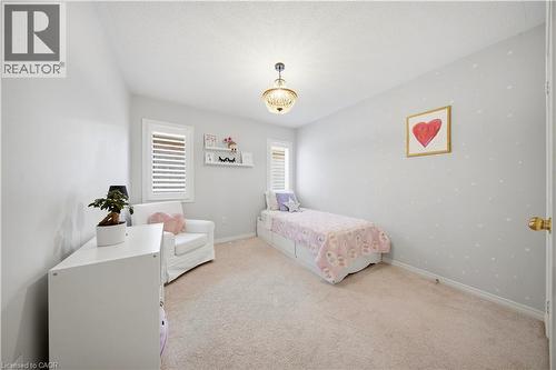 Neutral wall paint, ceiling-mounted light fixture, light-toned carpeting, window with internal blinds, and built-in shelving - 3352 Hiscott Avenue, Burlington, ON 
