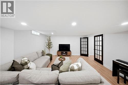 Recessed ceiling lighting, wood-finish flooring, and two sets of black-framed paneled doors - 3352 Hiscott Avenue, Burlington, ON 