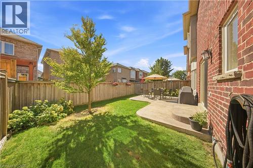 Expansive backyard featuring a manicured lawn, a large concrete patio, and a privacy fence - 3352 Hiscott Avenue, Burlington, ON 