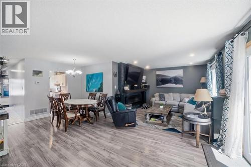Open-concept living space featuring wood-finish flooring, recessed lighting, a built-in fireplace, and a sliding glass door - 4804 John Street, Beamsville, ON 