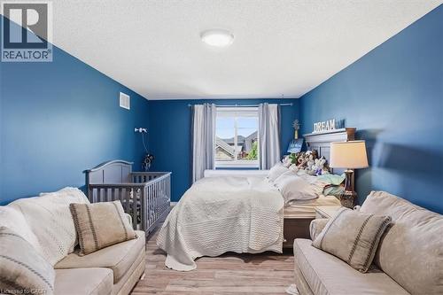 Wood-finish flooring with a durable surface, a large window with natural light, and a built-in overhead light fixture - 4804 John Street, Beamsville, ON 