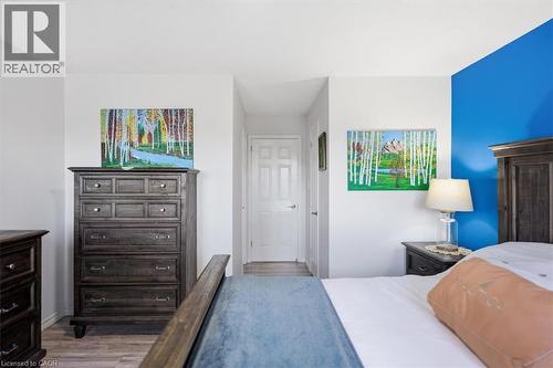Hardwood-style flooring throughout, white interior doors, and a partial accent wall - 4804 John Street, Beamsville, ON 