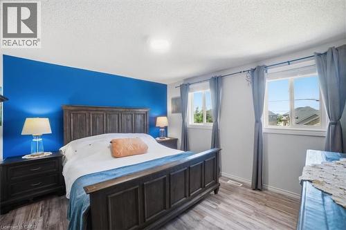 Wood-finish flooring with a vibrant accent wall and recessed lighting - 4804 John Street, Beamsville, ON 
