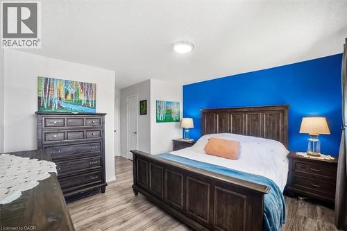 Wood-finish flooring throughout, featuring a bright accent wall and a flush-mount ceiling light - 4804 John Street, Beamsville, ON 