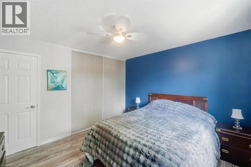Light wood-finish flooring with a white six-panel door - 4804 John Street, Beamsville, ON 