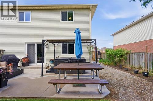 Expansive patio featuring concrete paving, a built-in spa, and a gravel pathway - 4804 John Street, Beamsville, ON 