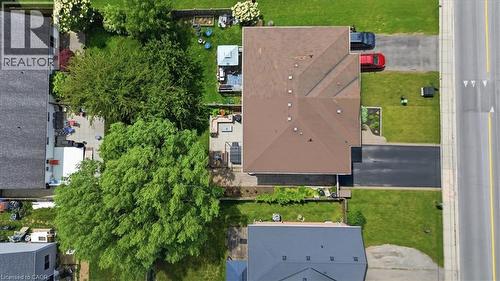Expansive property featuring a brown shingled roof, manicured lawn, and mature trees - 4804 John Street, Beamsville, ON 