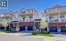 Townhome exterior featuring brick and siding facade, private balconies with white railings, integrated garages, and covered front entryways - 403 Westwood Drive Unit# 59, Kitchener, ON 