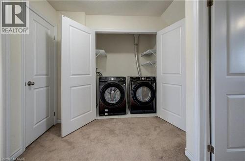 Laundry closet featuring a built-in shelf system, front-loading washer, and front-loading dryer - 403 Westwood Drive Unit# 59, Kitchener, ON 