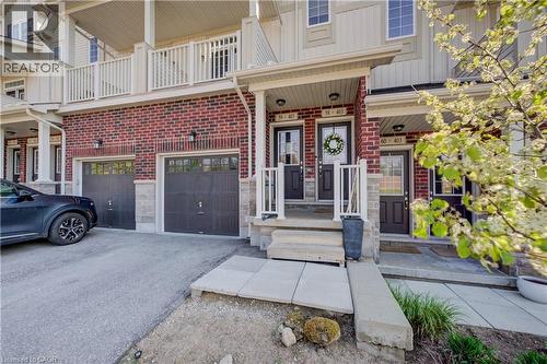 Brick and siding exterior featuring individual entryways with covered porches - 403 Westwood Drive Unit# 59, Kitchener, ON 