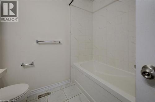 White porcelain bathtub with surrounding tile enclosure - 403 Westwood Drive Unit# 59, Kitchener, ON 